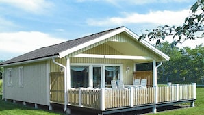 A single-story building with a covered porch and a fenced deck area. - 4 Person Holiday Home in Byxelkrok (Byxelkrok)