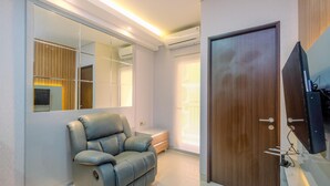 Ein modernes Wohnzimmer mit Relaxsessel, Holztür und Fernseher.