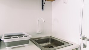A small kitchenette with a sink, a faucet, and a toaster. - Elegant And Comfortable Studio At Urbantown Serpong Apartment (South Tangerang)