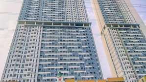 Un edificio de gran altura con varios pisos, que presenta un diseño arquitectónico moderno con fachada en forma de cuadrícula.