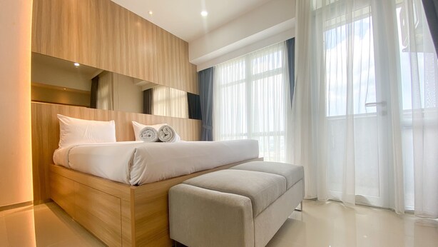 Un dormitorio moderno con una cama grande, una mesita de noche y un banco empotrado.
