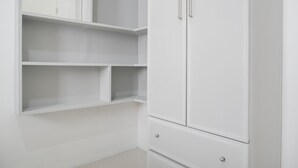 A white wardrobe with multiple shelves and drawers. - Cozy And Well Designed 2Br At Green Pramuka City Apartment (Jakarta)
