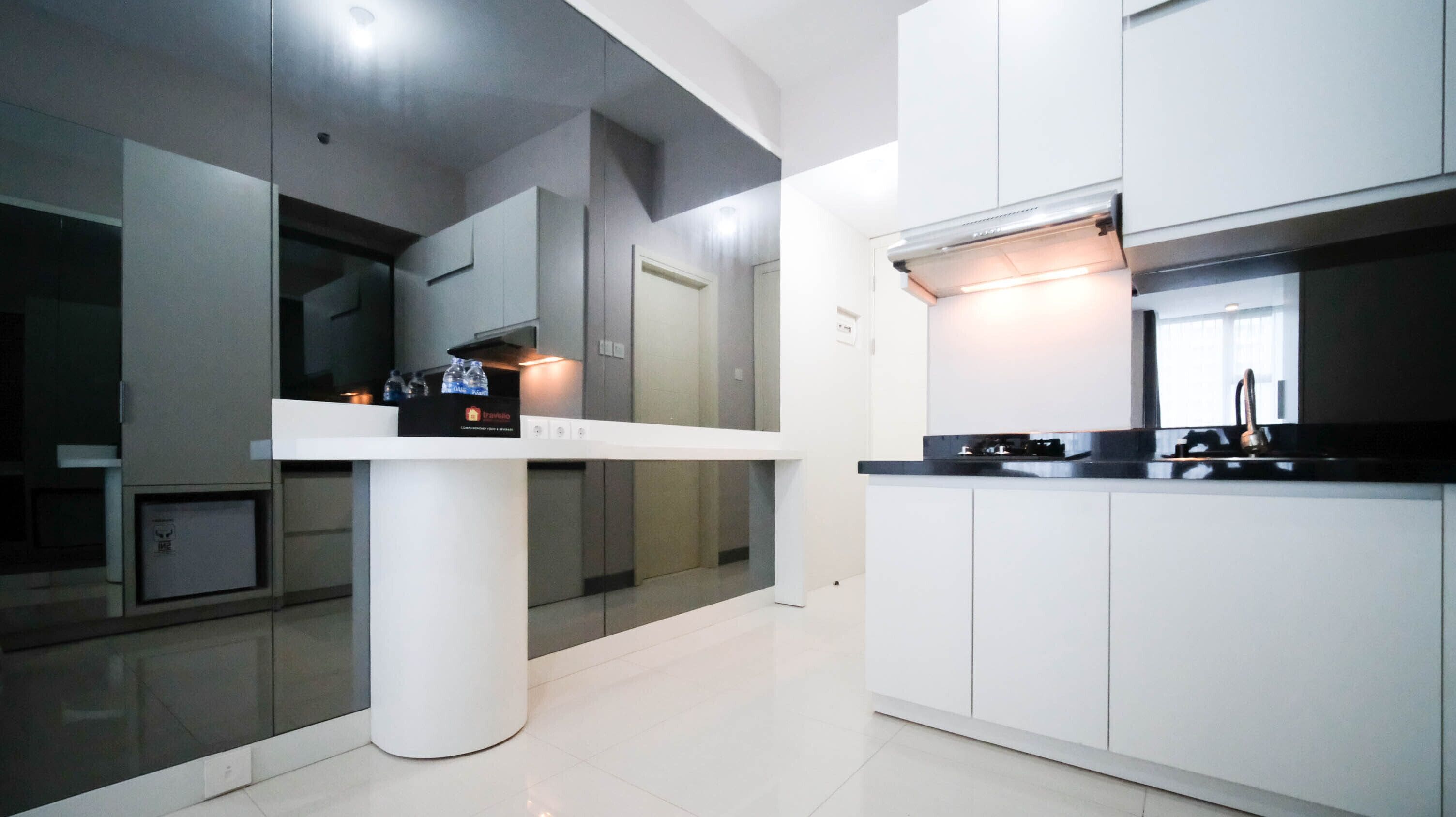 A modern kitchen with white cabinetry, a central island, and a built-in oven.
