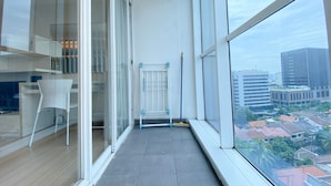 Een modern appartement met balkon, grote ramen en stadszicht.