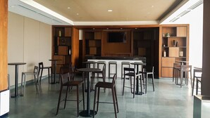 A spacious cafe with multiple seating areas, including round tables and high stools, and a central counter. - Comfort Stay 1Br At Branz Bsd City Apartment (Pagedangan)