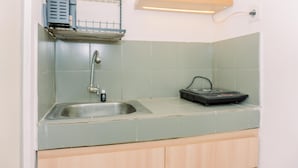 A kitchen with a stainless steel sink, a dish rack, and a built-in radio. - Comfort 2Br At 22Nd Floor Menara Kebon Jeruk Apartment (Jakarta)