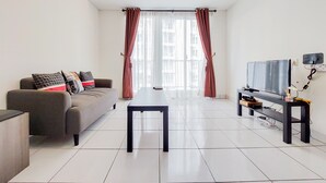 A modern living room with a sofa, a coffee table, and a TV on a stand. - Best Modern 2Br At Casa De Parco Apartment (South Tangerang)