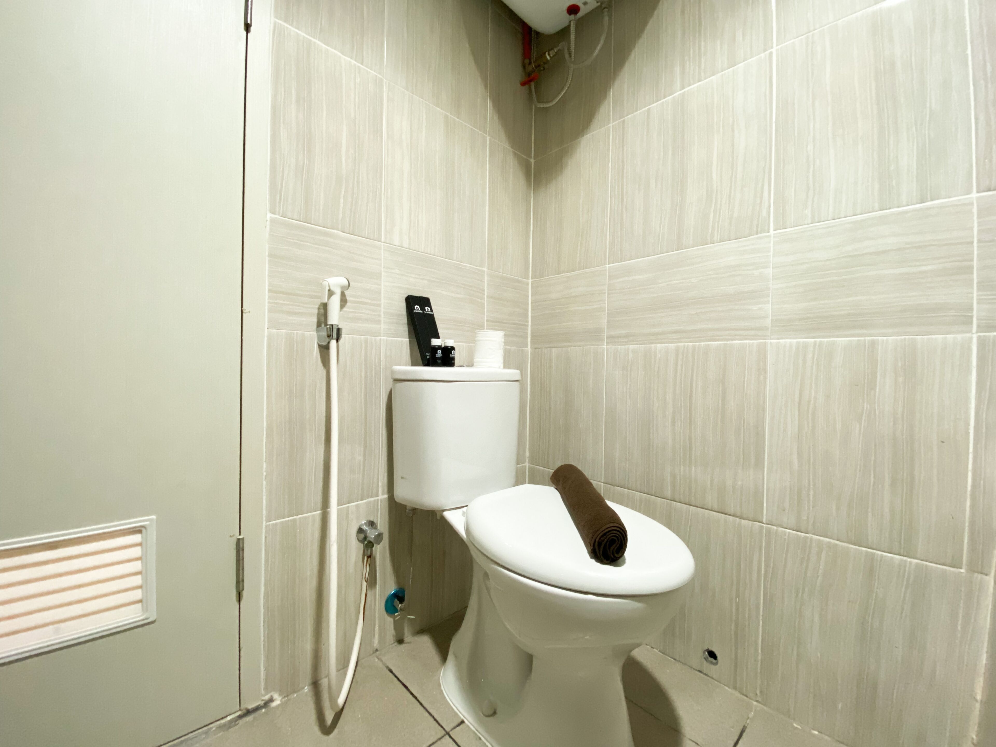 Ein modernes Badezimmer mit Toilette, Handtrockner und Papierhandtuchspender.
