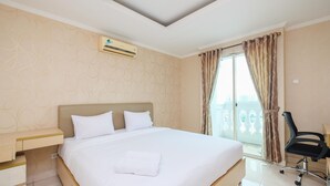 Hotellihuone, jossa on suuri sänky, työpöytä, ilmastointilaite ja näkymä ulos.