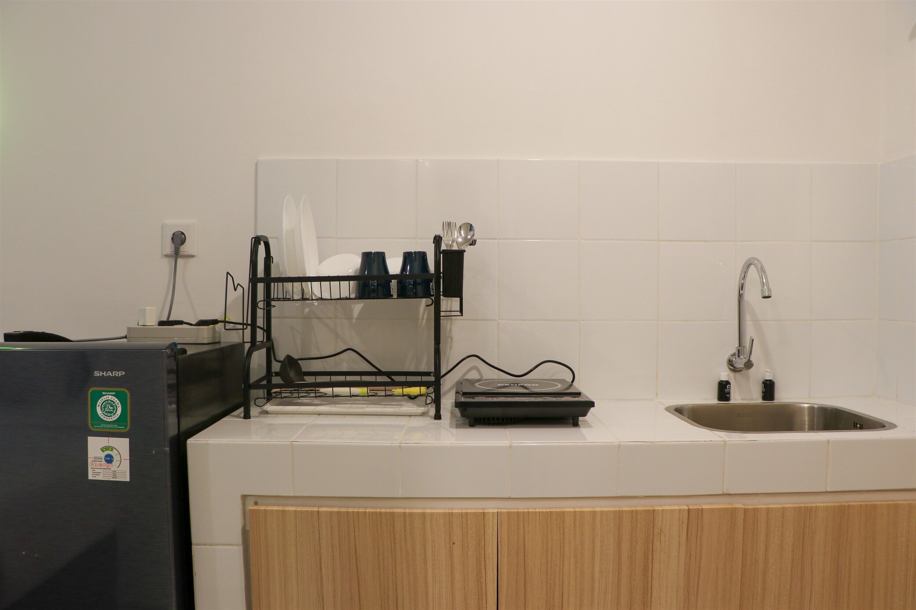 A kitchen with a dishwasher, sink, and wooden cabinets.