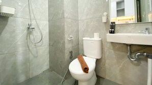 A modern bathroom with a shower, toilet, and sink. - Cozy Stay Studio At Sayana Bekasi Apartment (Tarumajaya)