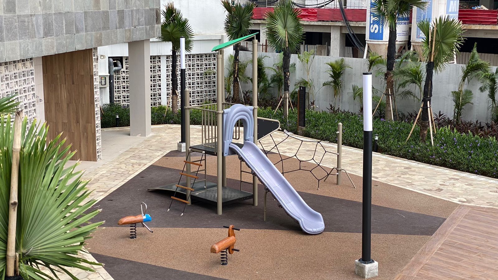 A playground with a slide, climbing structure, and swings.