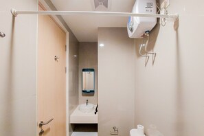 Een badkamer met toilet, wastafel en spiegel.