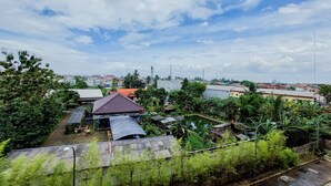A residential area with houses, a small pond, and lush greenery. - Cozy Living Studio Room At Baileys Apartment (South Tangerang)