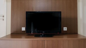 A flat-screen TV on a wooden cabinet in a room.