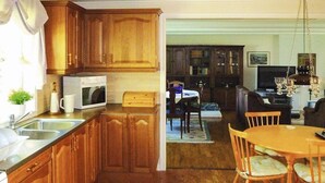 Una cucina con mobili in legno, un forno a microonde e un'area pranzo con tavolo e sedie.