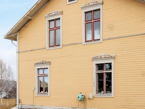 A yellow building with three windows, each with white trim and red frames. - 9 Person Holiday Home in Kalarne (Kälarne)