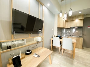 Cozy living space with a flat-screen TV, dining area, and kitchenette.