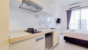 Ein modernes Hotelzimmer mit Küchenzeile, inklusive Herd, Spüle und eingebautem Geschirrspüler.