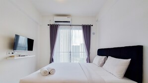 Ein Hotelzimmer mit Bett, Wandfernseher und Klimaanlage.