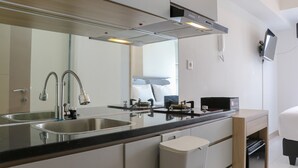 A modern kitchen with stainless steel appliances, a double sink, and a built-in oven. - Comfort Stay Studio Apartment At Tokyo Riverside Pik 2 (Teluknaga)
