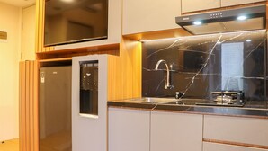 A modern kitchen with a built-in refrigerator, a microwave, and a stove. - Well Furnished And Cozy 2Br Tokyo Riverside Pik 2 Apartment (Teluknaga)