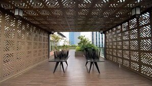 An outdoor seating area with patterned walls and a view of the cityscape.