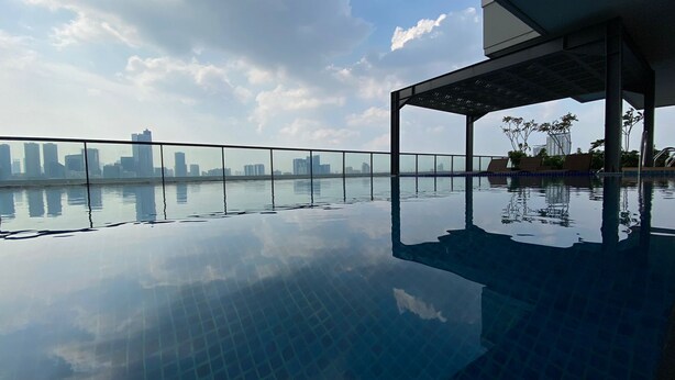 A rooftop infinity pool with a city skyline view.