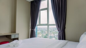 A hotel room with a bed, a nightstand, and a window with curtains. - Modern Look 1Br At 22Nd Floor Ciputra International Apartment (Jakarta)
