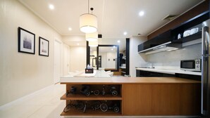 A modern kitchen with a wooden island, a microwave, and a sink. - Spacious 2Br At The Via And The Vue Apartment Surabaya (Surabaya)