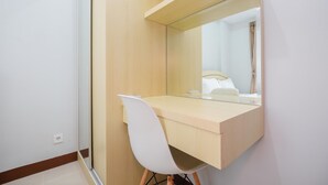 A modern room with a wooden desk, a white chair, and a large mirror.