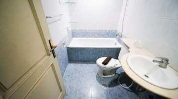 A small bathroom with a toilet, bathtub, and sink.