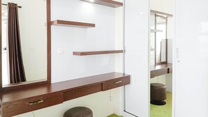 A modern bathroom with a wooden vanity, a large mirror, and a green carpet. - Comfort 1Br At Vida View Makassar Apartment (Makassar)