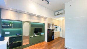 Une cuisine moderne avec un plancher en bois, des appareils électroménagers intégrés et un mur d’accent vert.