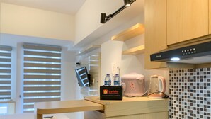 A compact kitchenette with a countertop, a coffee maker, and a water dispenser. - Chic And Cozy Studio Tokyo Riverside Pik 2 Apartment (Teluknaga)
