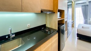 Une cuisine moderne avec un plan de travail noir, un évier en acier inoxydable et des armoires en bois.