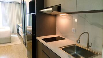 A modern kitchen with a built-in stove, a stainless steel sink, and a sleek countertop.