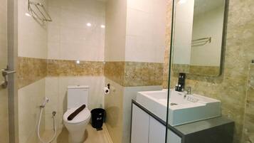 A modern bathroom with a toilet, bidet, and sink.