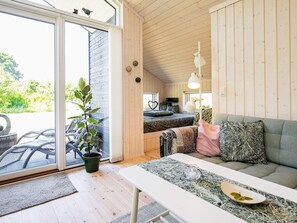 A cozy room with a sofa, a table, and a potted plant.