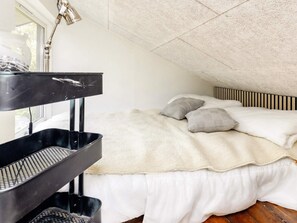 A bedroom with a bunk bed, a window, and a ceiling with a textured finish. - 4 Star Holiday Home in Storvorde (Storvorde)