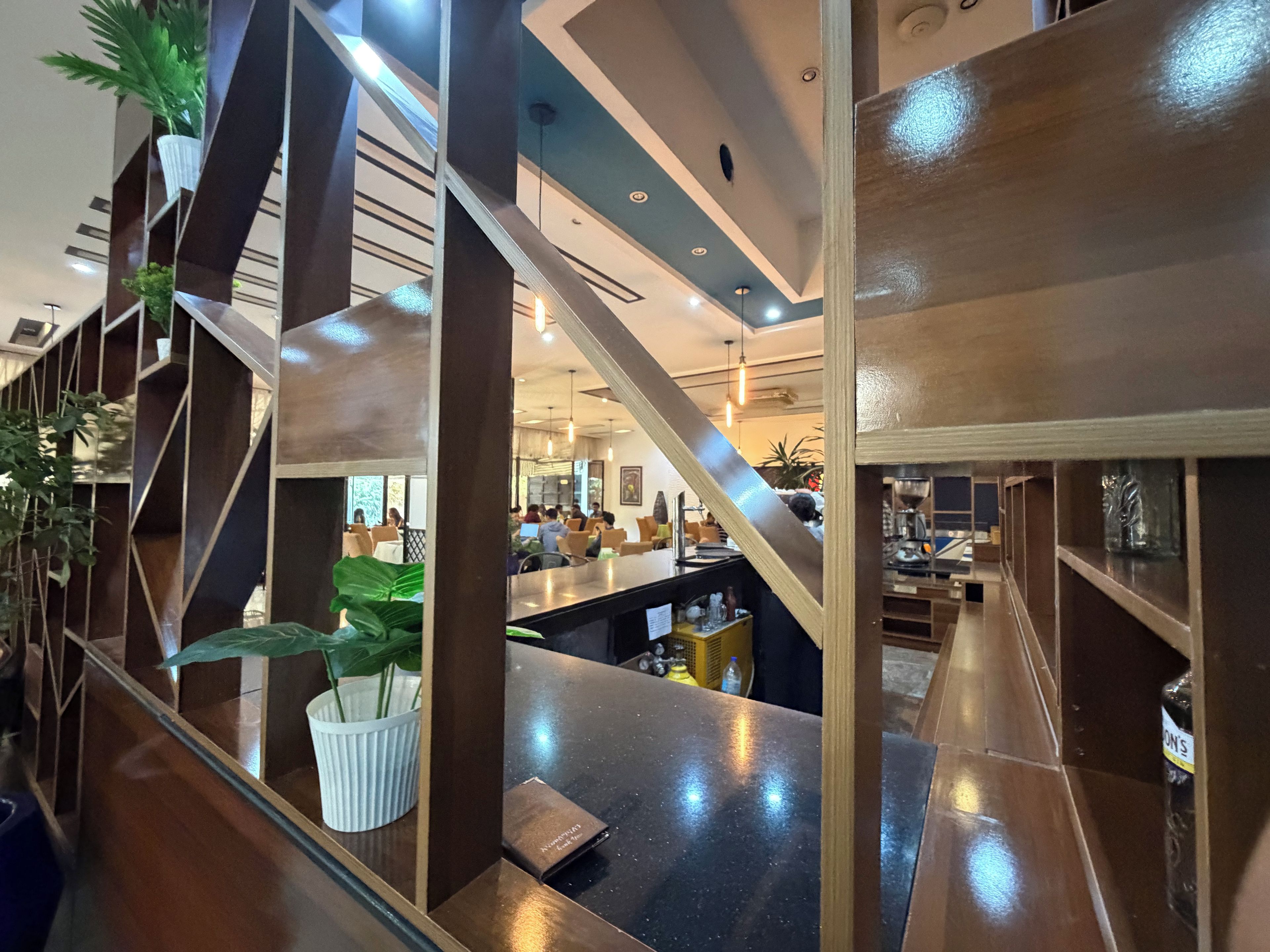 A modern interior with a bar area, seating, and a staircase.