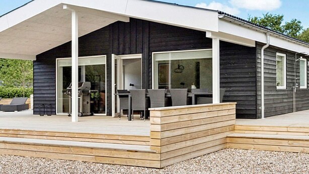 A modern house with a covered patio, large windows, and a wooden deck. - 8 Person Holiday Home in Hurup Thy-by Traum (Hurup Thy)
