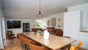 A modern dining area with a large wooden table, brown and yellow chairs, and a pendant light. - 8 Person Holiday Home in Hurup Thy-by Traum (Hurup Thy)
