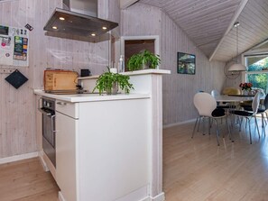 Enjoy cooking in this well-equipped kitchen with a central island, oven, and stainless steel range hood.