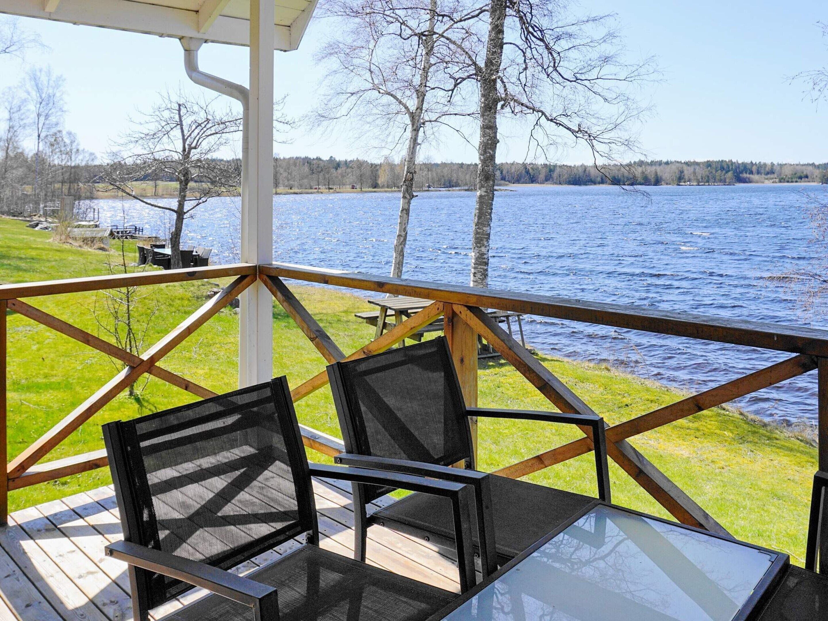 Una terraza con mesa y sillas con vistas a un lago.
