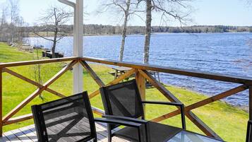 Una terraza con mesa y sillas con vistas a un lago.