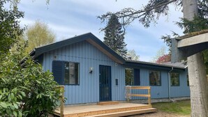 A small, single-story blue cabin with a wooden deck and a front door. - Seaside Retreat in Dronningmolle-by Traum (Dronningmolle)