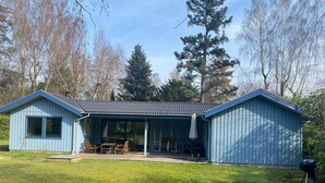 A blue metal building with a covered patio area, a barbecue grill, and a satellite dish. - Seaside Retreat in Dronningmolle-by Traum (Dronningmolle)