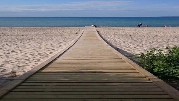 A wooden boardwalk leading to a sandy beach with a clear blue sky. - Seaside Retreat in Dronningmolle-by Traum (Dronningmolle)