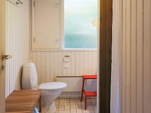 A small, compact bathroom with a toilet, a sink, and a window.